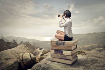 girl with binoculars-sitting on books