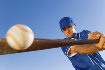 baseball player hitting ball with bat