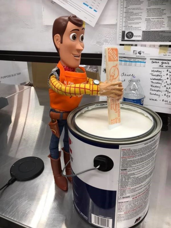 Image showing Toy Story’s Woody stirring paint in a Home Depot Store